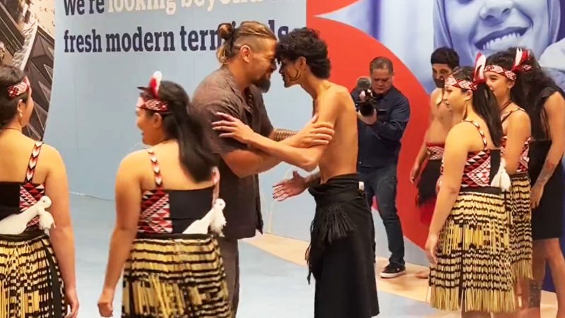 Jason Momoa engages in a hongi with pōwhiri performer at Auckland Airport